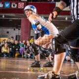 Wheelie with a star on her helmet skating for roller vortex.