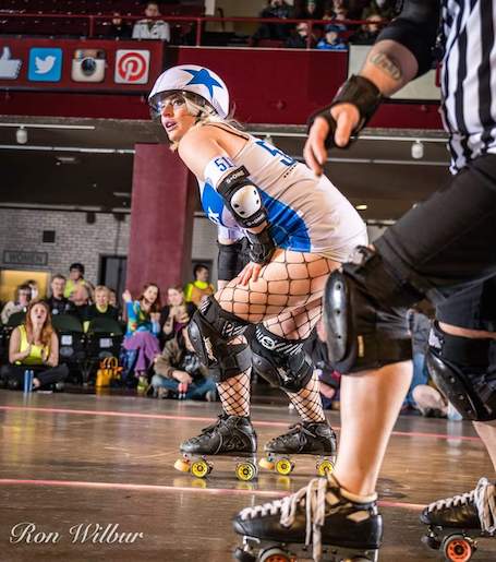 Wheelie with a star on her helmet skating for roller vortex.